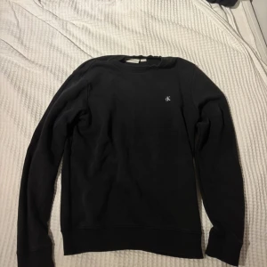 Svart sweatshirt från Calvin Klein - Säljer en svart Calvin Klein tröja svart i skick 9/10 mycket bra skick. Skicket är 9/10 pga tröjan enbart används så fåtal gånger. Storlek 16 år 170 cm