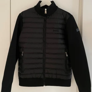 Hugo Boss Cardigan Jacka - Snygg stilren sällsynt klass Hugo Boss cardigan jacka ny bara testad. Jackan har dragkedja framtill, två fickor med dragkedja och hög krage. Perfekt för dig som vill ha en stilren och modern look med klass, pris kan diskuteras vid snabb affär.