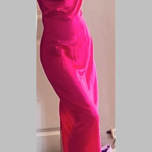 Ceriserosa klänning från Parisian - Säljer en snygg ceriserosa klänning från Parisian. Klänningen har en slät, glansig yta och är figurnära med en elegant drapering. Materialet är 92% polyester och 8% elastan, vilket gör den stretchig och bekväm. Perfekt för dig som vill sticka ut med färg!