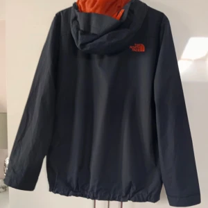 Svart vindjacka från The North Face - Säljer en svart vindjacka från The North Face Jackan är i fint skick och  väl omhändertagen inga skador eller defekter (storlek M)