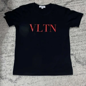 Valentino t shirt - Snygg svart t-shirt från Valentino med röd VLTN-logga på framsidan. Perfekt för en stilren look. Kortärmad och i mjukt material.