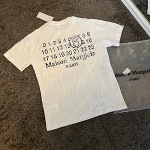 MAISON MARGIELA T-SHIRT - Hej, säljer denna Maison margeial T-shirts/tee. Allt medföljer dvs tags och poly bag. T-shirten är i nyskick och väldigt bra kvalité, tröjan behövs endast strykas.