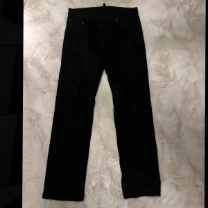 Svarta jeans från Dsquared2, stl 46 - Snygga svarta jeans från Dsquared2 i klassisk rak modell. Jeansen har fem fickor, diskreta nitar och patch bak i midjan. Nypris på dessa jeans är 4600, använda fåtal gånger så i mycket bra skick.   Allt OG fås med