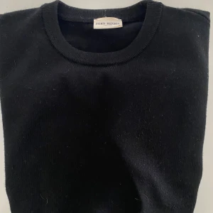 Svart stickad tröja från John Henric - Klassisk svart stickad tröja  i 100% merinoull från John Henric. Enkel och stilren modell som är perfekt att matcha med jeans. Nypris 999 kr