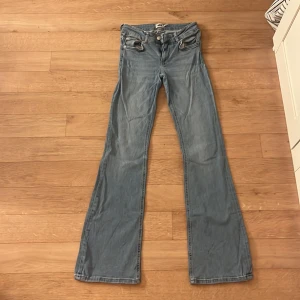 Ljusblå bootcut jeans XS från 157 - Säljer ett par ljusblå jeans från 157 i storlek XS med full längd. Jeansen har klassisk femficksdesign och bootcut-ben som ger en snygg siluett. Perfekta för dig som gillar en retro vibe och vill ha ett par jeans med lite extra vidd nertill.