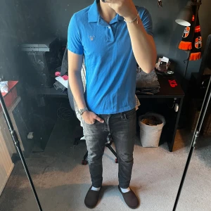 Gant pikétröja  - Säljer en klassisk blå pikétröja från Gant med korta ärmar och krage. Tröjan har en liten broderad logga på bröstet och är tillverkad i mjuk bomull. Perfekt för en clean och stilren look. Skriv för mer bilder