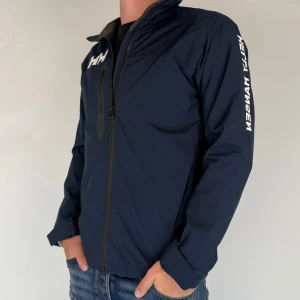 Helly Hansen Jacka - Vi säljer nu denna riktigt snygga jacka i märket Helly Hansen! Jackan är i storlek S, modellen på bilden är 180cm 75kg. Jackan är i gott skick utan defekter! Skriv för frågor och funderingar.