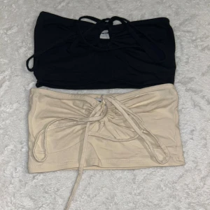 2 bandeau tubtoppar från Noisy May - Två bandeau tubtoppar från Noisy May, en i svart och en i beige. Båda har snörning framtill som ger en snygg rynkad effekt. Båda supersnygga och i mycket bra skick 🥰