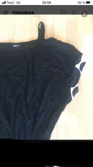 Svart och vit prickig kortklänning - Cool kortklänning med svart överdel och vit kjol med stora svarta prickar. Klänningen har breda axelband och ett markerat midjeparti som ger en snygg siluett. Perfekt för dig som gillar grafiska mönster och kontraster.