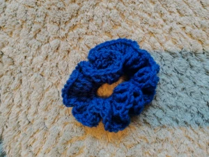 Blå virkad scrunchie - Snygg blå scrunchie som är virkad av mig. Perfekt för att ge din frisyr extra volym och färg. Den har en rund form och är riktigt bekväm att använda i håret. Passar dig som gillar att sticka ut med färg och stil.