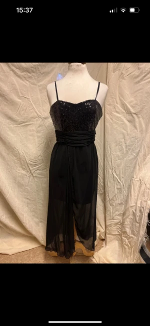 Svart festklänning med paljetter  - Svart festklänning med paljetter. 105 cm lång från bysten. 