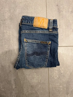 Mörkblå jeans från nudie jeans - Säljer ett par mörkblå/ ljusblå jeans från nudie jeans, börjar få skön tvätt. Modell: Lean Dean färg: blue vibes nypris ligger på runt 1600