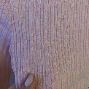 Rosa ribbad långärmad tröja H&M - Supersöt ljusrosa långärmad tröja från H&M med ribbad struktur. Tröjan är slim fit och har rund halsringning. Perfekt att styla med jeans eller kjol för en chill look. Materialet är mjukt och stretchigt, troligtvis bomull med inslag av syntet. Lite genomskinlig men det kan vara snyggt med en fin BH under! 