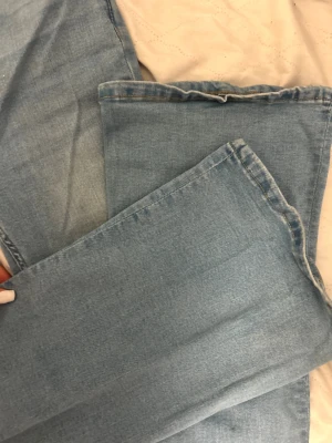 ljusblå bootcut jeans - Ljusblå  jeans med klassisk bootcut passform och raka ben. Jeansen har fem fickor, dragkedja och knappstängning. Tillverkade i mjukt jeanstyg med snygg tvättad look och detaljerad söm på bakfickorna.