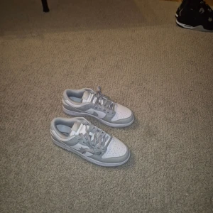 Nike Dunk Low vit och grå sneakers. - Nike Dunk Low sneakers. Toppskick aldrig använt.
