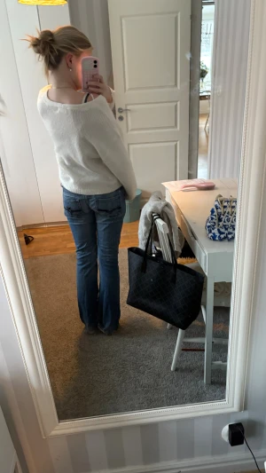 Blå bootcut jeans från Guess - Säljer ett par klassiska blå jeans från Guess med bootcut passform. Jeansen har snygga slitningar, dragkedja och knapp med Guess Jeans 1981-logga. De är tillverkade i jeansmaterial och har låg midja. Perfekta för dig som gillar en tidlös och avslappnad look. Ett håll vid skrevet, men inget som syns, och en trasig dragkedja men inget som påverkar byxorna! 