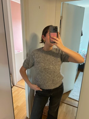 Grå stickad kortärmad tröja Gina Tricot - Mysig grå stickad tröja från Gina Tricot med korta ärmar och rund hals. I perfekt skick storlek L💗 passar även M