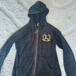 Svart hoodie med guldtryck och huva - Svart kofta, väl använd. Storlek 170 men skulle säga att den sitter mer som M. Vet dessvärre inte märket :(  Jag finns tillgänglig i Skövde, Borås & Värnamo om ni vill mötas istället för att betala frakt🙈❤️🥰