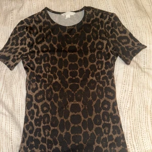 Leopardmönstrad topp från H&M - Snygg topp från H&M med leopardmönster i bruna och svarta toner. Materialet känns mjukt mot kroppen. Tröjan är helt oanvänd tyvärr finns etiketten inte kvar på