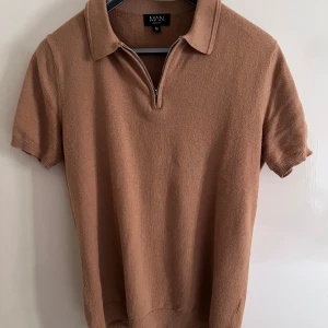 Beige pikétröja med dragkedja MAN - Snygg beige pikétröja från BoohooMAN i stickad bomullsmix. Tröjan har korta ärmar, klassisk krage och en stilren dragkedja framtill. Perfekt för dig som gillar en clean och avslappnad look.