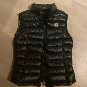 Moncler väst - Säljen denna fina svarta moncler väst i storlek xs, moncler räknar med bokstäver och 0 är xs enligt deras storleksguide. Den är dock ganska liten även om det är xs.