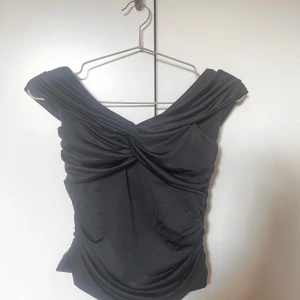 Svart omlottopp från Vero Moda  - Snygg svart omlottopp från Vero Moda i storlek XS. Helt oanvänd utan lappar