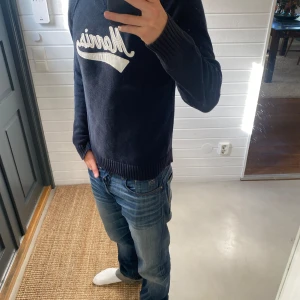 Marinblå stickad tröja Morris - Säljer en marinblå stickad tröja från Morris,  Jag är 182 cm och väger 82 kg. Skriv om ni har några funderingar