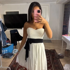 Vit axelbandslös klänning med svart rosett - Supersöt vit axelbandslös klänning 