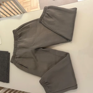 Grå mjukisbyxor från Yeezy - Säljer ett par grå mjukisbyxor från Season 6 i storlek L. Byxorna har resår i midjan och vid bensluten samt sidofickor. Perfekta för en chill och avslappnad stil. Tillverkade i mjukt bomullsmaterial för extra komfort.