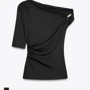 Zara topp - Snygg svart topp med oneshoulder-design och en cool metallring på axeln. Toppen har draperad effekt och halvlånga ärmar, vilket ger en trendig och unik look. Perfekt festtopp!! Prislapp kvar ❤️❤️