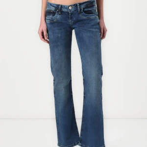 Blå bootcut jeans från LTB - Snygga blå jeans från LTB med bootcut passform och låg midja. Jeansen har klassisk femficksdesign, ljus tvätt och subtila slitningar. Tillverkade i mjukt denim med stretch för extra komfort. Perfekta för dig som gillar en avslappnad men trendig look.