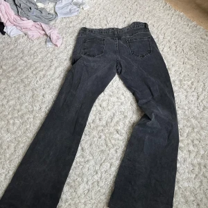 Svarta bootcut jeans med raka ben - Säljer ett par svarta jeans med bootcut och raka ben. Jeansen har klassiska bakfickor och är tillverkade i ett robust denimtyg. Perfekta för dig som gillar en avslappnad och tidlös stil.