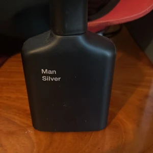 Man Silver parfym från Zara - Minimalistisk parfym med stilren design från Zara. Flaskan är svart och har texten 'Man Silver'. Perfekt för dig som vill ha en modern och enkel look på parfymhyllan.