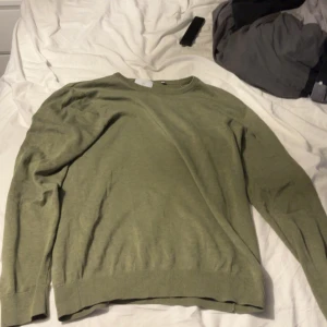 Olivgrön långärmad tröja - Storlek m men passar s En stilren olivgrön långärmad tröja med rund halsringning. Tröjan har ribbade muddar vid ärmslut och nederkant, vilket ger en snygg och enkel look. Perfekt att matcha med jeans eller chinos för en avslappnad stil.