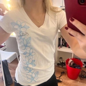 Blommig T-shirt - Jättesöt tight T-shirt med blåa blommor och v neck. 