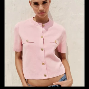 Ljusrosa stickad blus med guldknappar Zara  - Från Zara - använd 1 gång. Supersöt ljusrosa stickad blus med korta ärmar och snygga guldknappar framtill. 