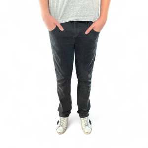 Nudie jeans  - Snygga svarta jeansbyxor med klassisk femficksdesign och raka ben. Jeansen har normal passform och är tillverkade i slitstarkt denimtyg. Perfekta för en avslappnad och stilren look. Modellen heter slim Jim och de är storlek 31:32