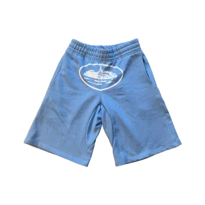 Blå corteiz shorts - Snygga ljusblå shorts från Corteiz med elastisk midja och tryck framtill. Relaxed passform, sidofickor och en bakficka. Tillverkade i mjuk bomull som är skön mot huden, perfekta för streetwear och chill dagar.  👉 Endast använda en gång, i nyskick. Tyvärr för små, fick dem i present.