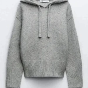 Stickad hoodie från Zara  - Mysig grå stickad hoodie med huva och snörning. Tröjan har ribbade muddar och nederkant, samt lång ärm. Perfekt för kyliga dagar och enkel att matcha med jeans eller leggings.