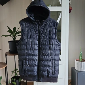 Svart väst strl L - Svart väst,lätt fodrad i märket Urban classics strl Large,dragkedja & luva,2 fickor med rakedja.  80:-