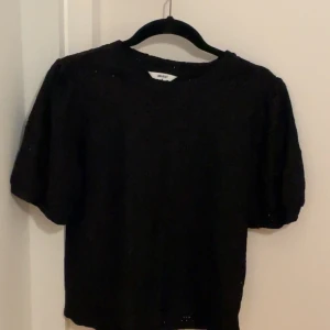 Svart spetsblus från Object - Supersnygg svart blus från Object med korta puffärmar och vackert spetsmönster. Blusen har rund halsringning och är genombruten med broderade detaljer som ger en cool och feminin vibe.