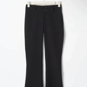 Svarta bootcut kostymbyxor - Svarta kostymbyxor med bootcut-silhuett och två knappar i midjan. Byxorna har bälteshällor, bakfickor med knapp och en klassisk, stilren look. Perfekta för dig som gillar Y2K-vibbar och vill ha en snygg passform med lite utsvängda ben.