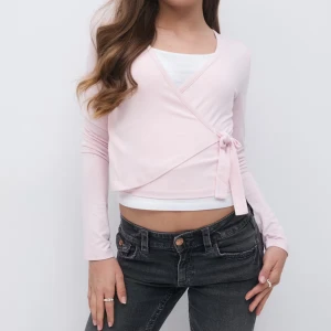 Ljusrosa omlottopp med knyt - Säljer denna slutsålda supersöt ljusrosa omlottopp med lång ärm och knyt i sidan. Toppen  har en v-ringad design som ger en fräsch och trendig look. Perfekt att styla med jeans eller kjol för en chill vibe. Mjuk och skön i materialet. Max använd 3 ggr, säljer för 230, ordnarie pris är 300kr, från Gina tricot