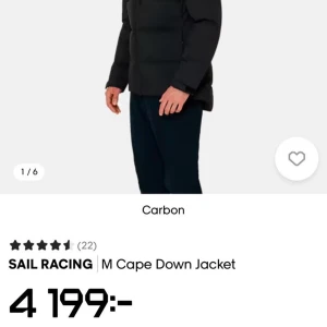 Svart dunjacka från Sail Racing - Svart dunjacka från Sail Racing med huva och dragkedja framtill. Jackan har logga på bröstet och ärmarna, samt en quiltad design som ger en sportig vibe. Perfekt för kalla dagar och riktigt snygg passform.