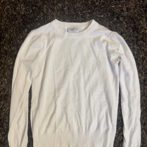 Vit långärmad tröja från Saint tropez  - Klassisk vit långärmad tröja från Saint med rund halsringning och ribbade muddar. Enkel och stilren design som passar perfekt till jeans eller kjol. Tillverkad i mjukt bomullsmaterial för en skön känsla hela dagen.