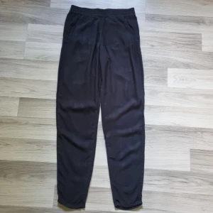 Svarta byxor från H&M Divided - Svarta byxor från H&M Divided i storlek 34. Byxorna har resår i midjan och två sidofickor. Tillverkade i mjukt viskostyg som känns skönt mot huden. Perfekta för en chill och avslappnad stil.