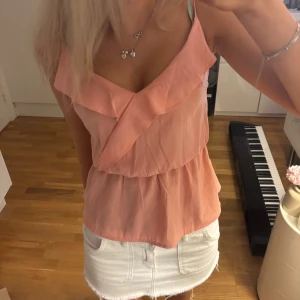 Ljusrosa volangig linnetopp - Säljer en ljusrosa linnetopp med volangdetaljer och smala axelband, super söt och passar till många tillfällen!