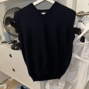 Mörkblå ullväst från Wolsey  - Klassisk mörkblå stickad väst från Wolsey. Det står XL på taggen men passar senare xs/s. Västen har v-ringning och ribbade kanter, perfekt att slänga över en skjorta för en clean look. Tillverkad i mjuk ull som håller dig varm under kyliga dagar. Fråga hjärna om mått eller annat😁