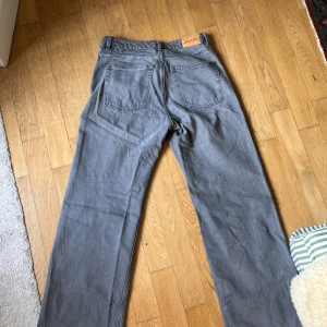 Grå jeansbyxor från Monki, raka - Säljer ett par grå jeansbyxor från Monki i rak modell. Byxorna har klassisk femficksdesign, hällor för bälte och knapp- samt dragkedjestängning. Perfekta för dig som gillar en enkel och clean look.
