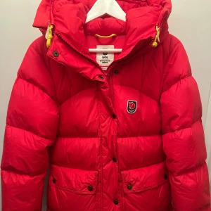 Röd Fjällräven Expedition dunjacka XS - Säljer en röd fjällräven expedition down lite jacket. Jackan har stora fickor både utanpå och inuti. Köpt på naturkompaniet, nypris 7499kr. Skriv för frågor.❤️